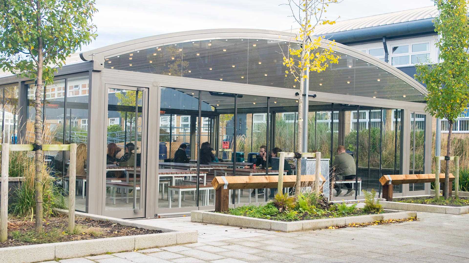 A large detached school dining room canopy with students sitting inside